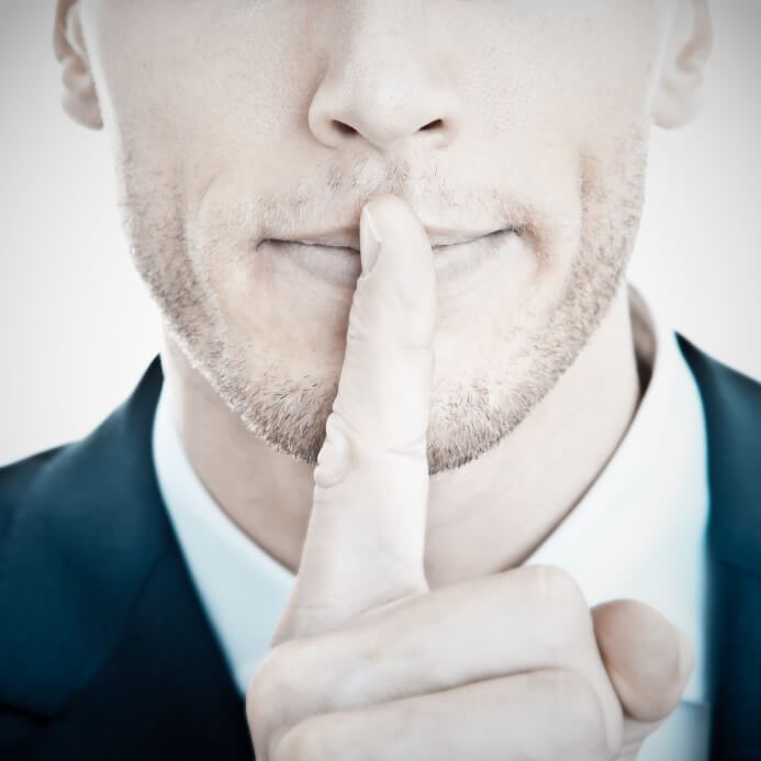 Top secret! - Young businessman with finger on his lips